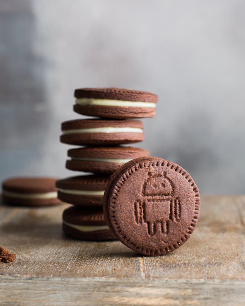 Close-up of brown chocolate sandwich cookies stacked artistically, showcasing food photography.